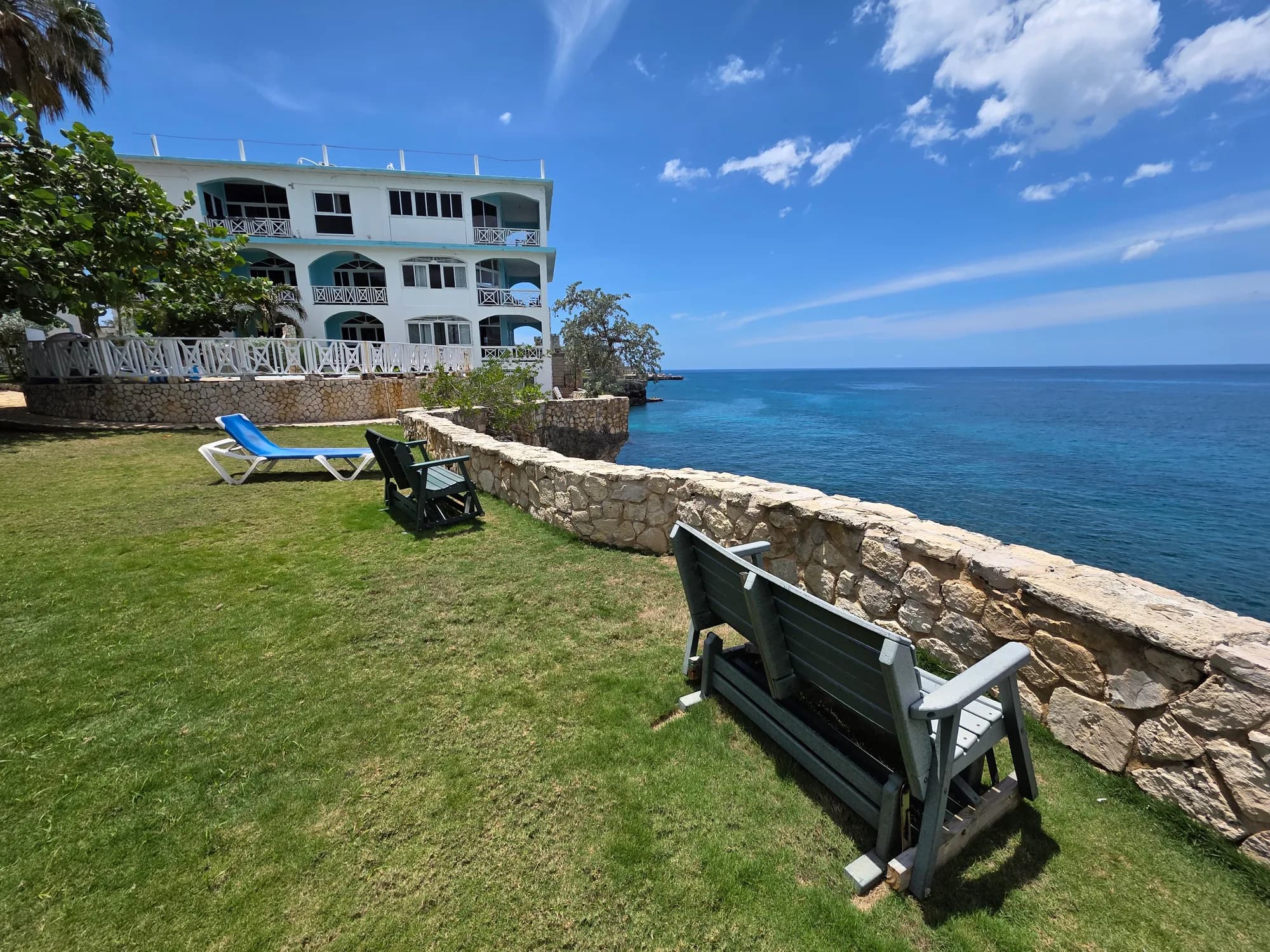 A bench on the cliff-top lawn over the Caribbean Sea at Home Sweet Home Resort