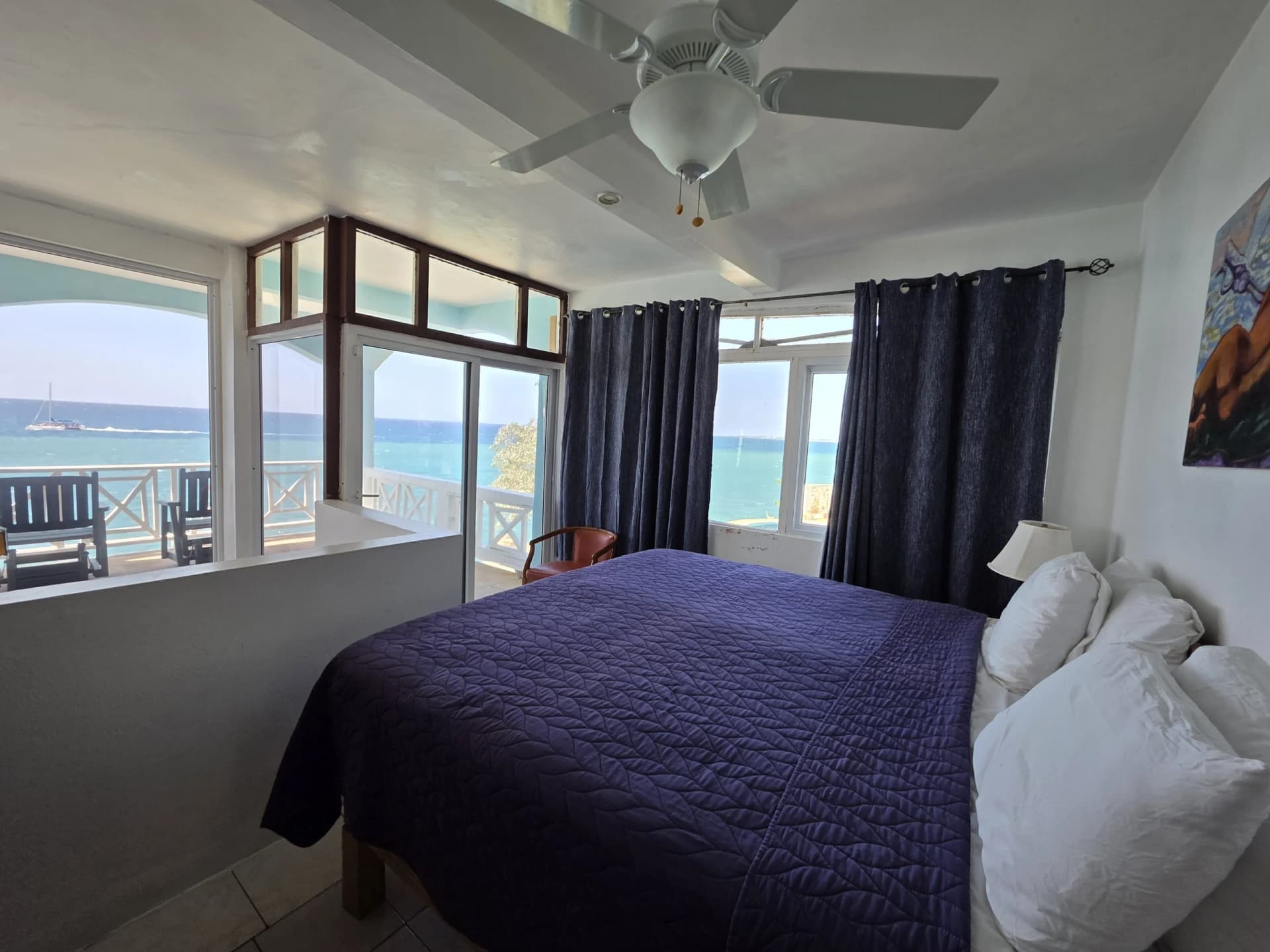 King bed with sea-view windows and a private balcony in the Executive Suite, Room 11