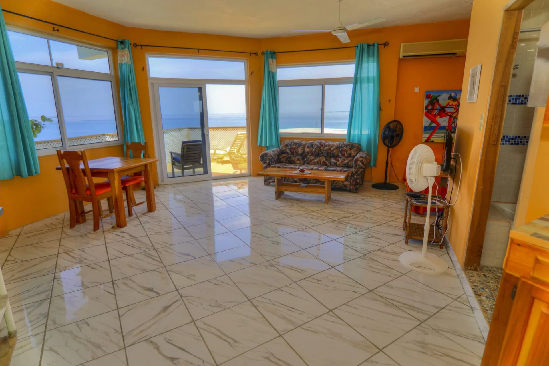 Bright living and dining area with sea-view windows in the Owner's Suite, Room 17