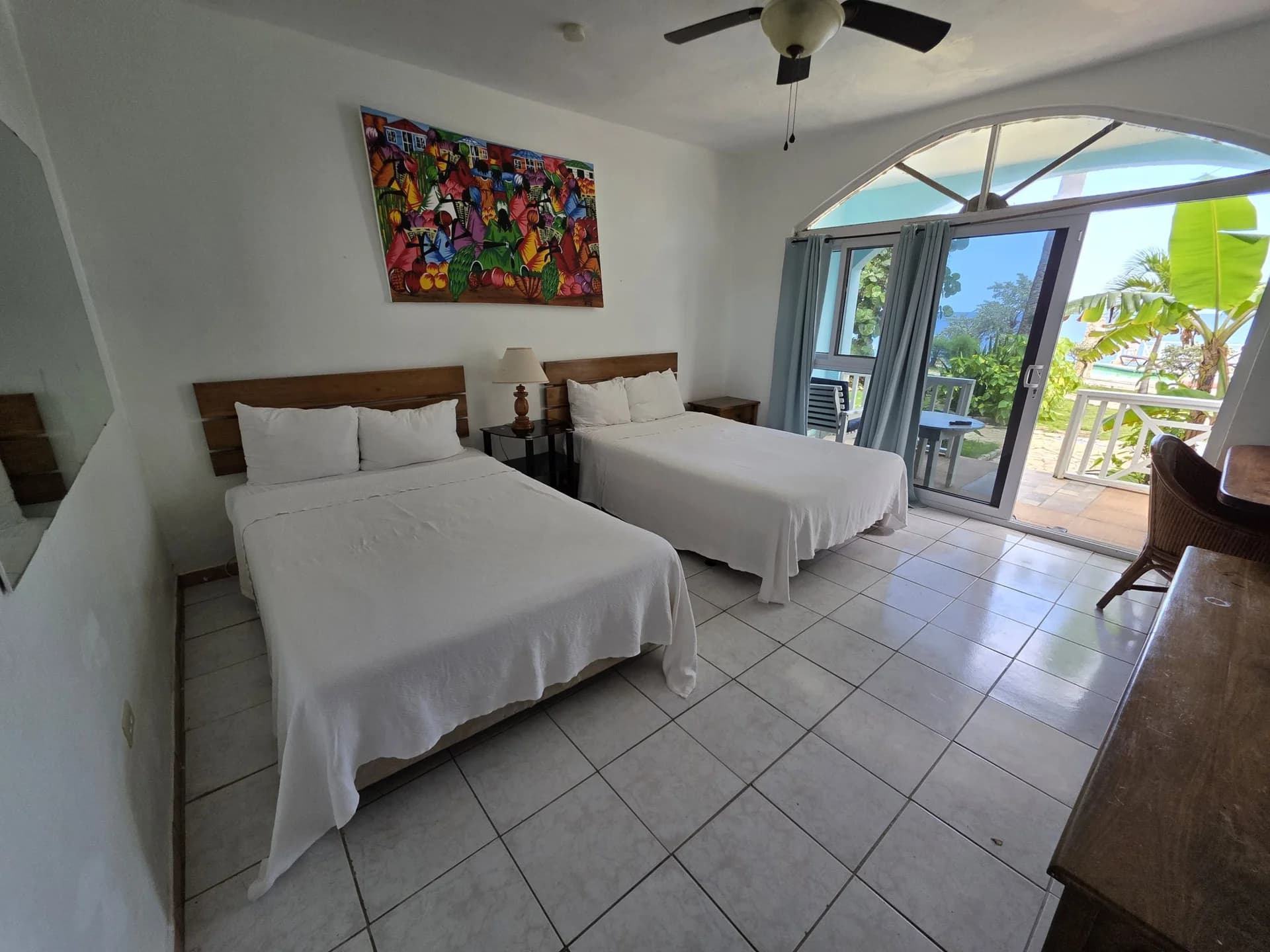 Two double beds with sliding doors to a sea-view balcony in Seaview Deluxe Room 1