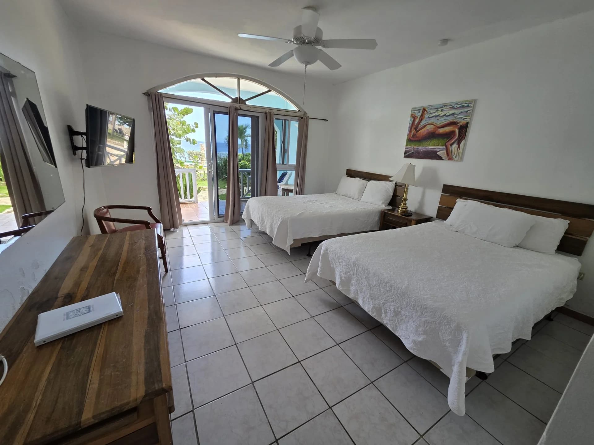 Two double beds with balcony doors and sea views in Seaview Deluxe Room 3